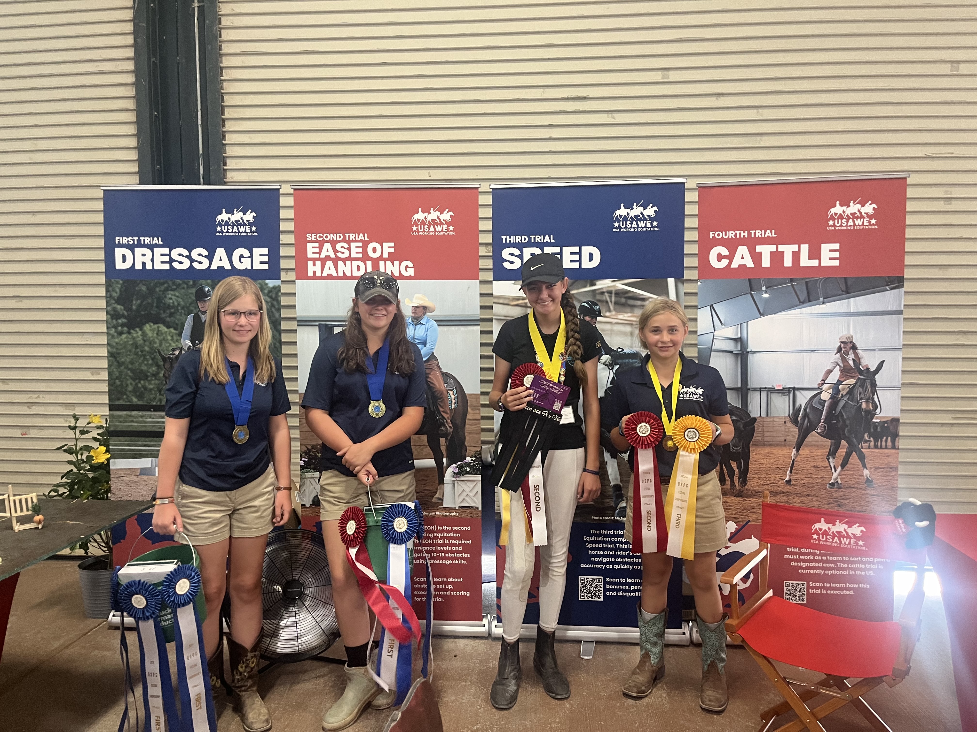 Landyn Riddle (right) and  Pony Club Team in front of the WE booth at USPC Festival 2024